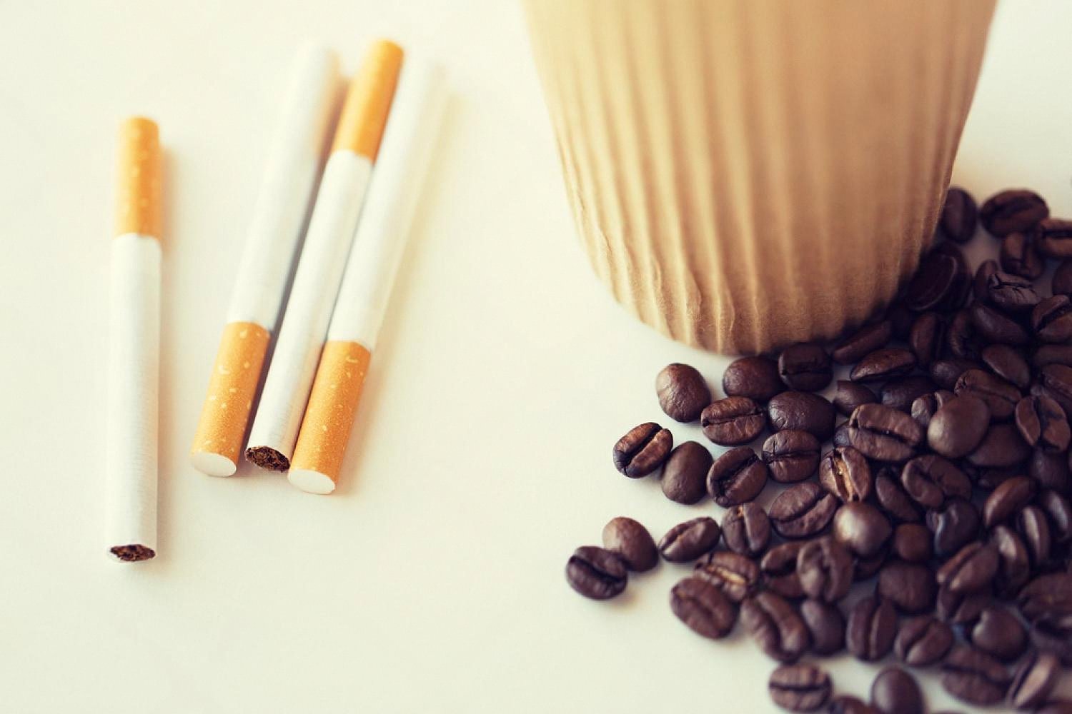 Traditional filter cigarettes next to coffee beans representing legacy nicotine products in the UAE